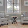 a white couch and a chair in a room with a window